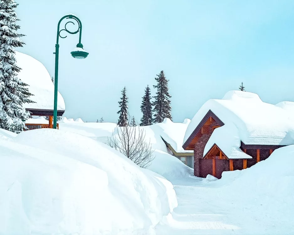 Cozy wooden cabins blanketed in deep snow in the village area of Big White Ski Resort, British Columbia, Canada