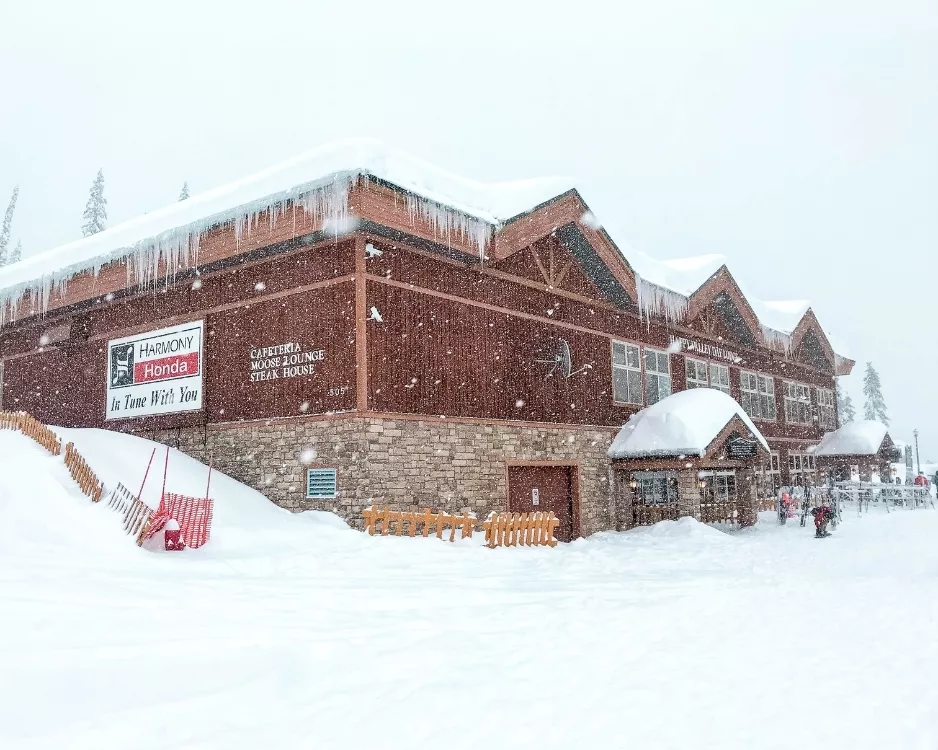 Snow falling at the base lodge with icicles hanging from the roof at Big White Ski Resort in British Columbia, Canada.