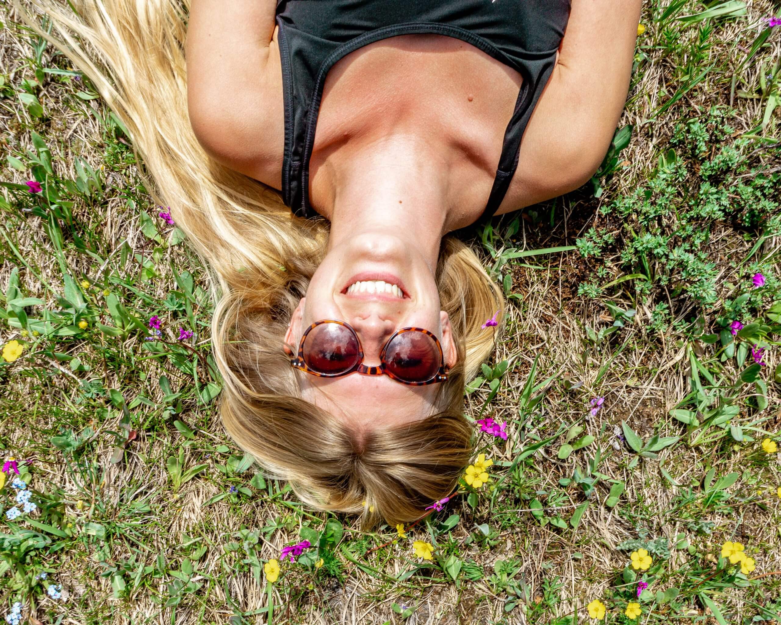 Jo laying in some flowers on a meadow.