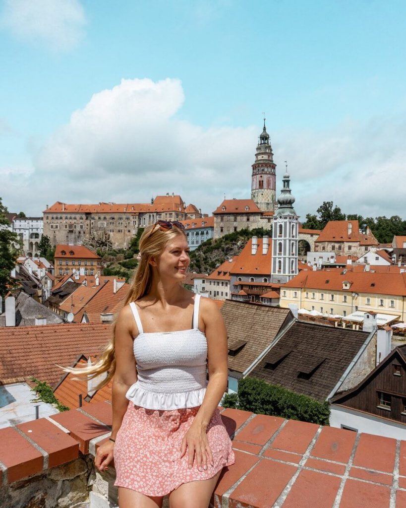 Girl sitting in front of the famous castle in Cesky Krumlov in southern Bohemia.