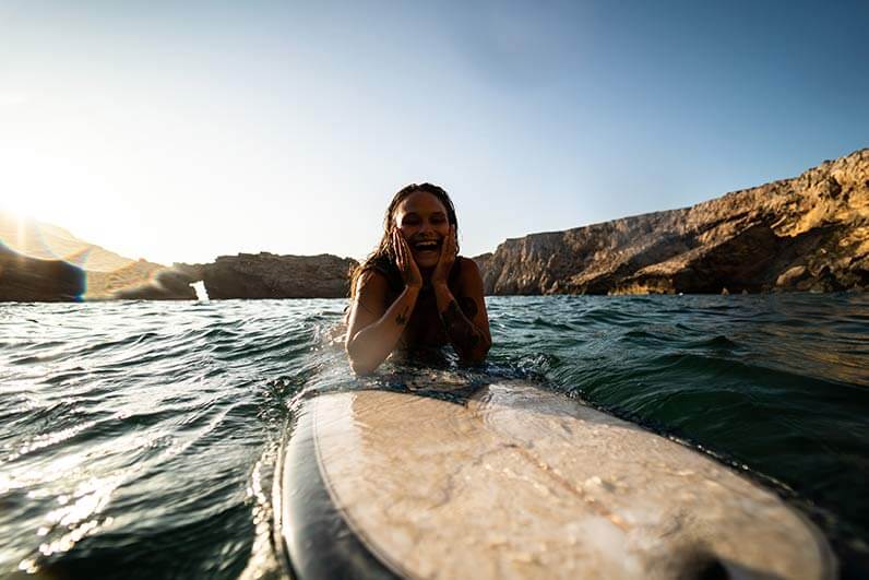 A girl surfing at Sagres in Portugal.