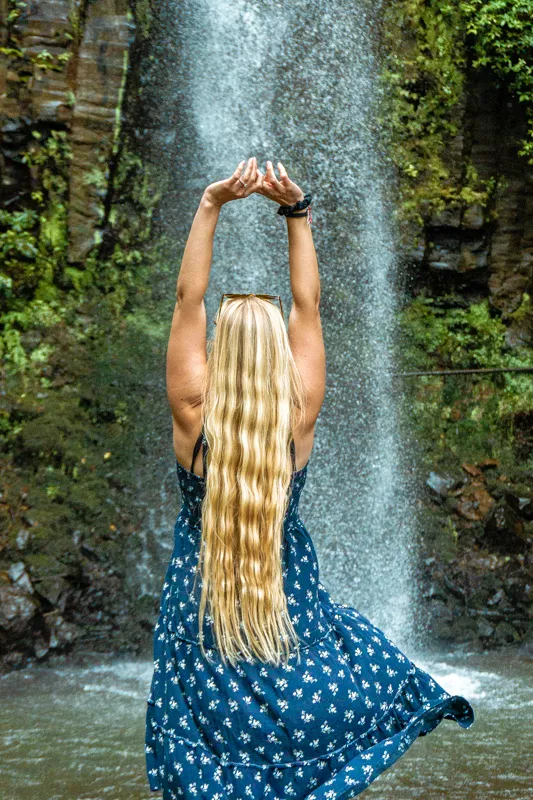 Stunning photo of a girl taking in the view of Aguage Waterfall in Santana.