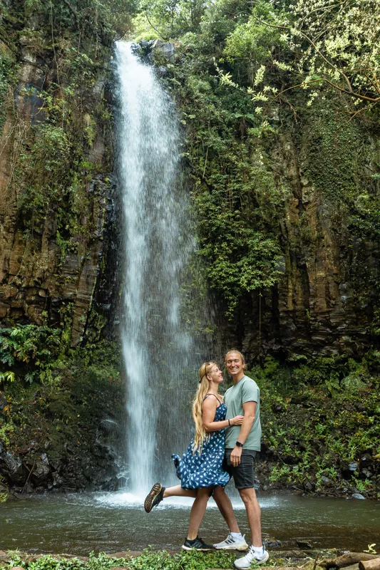 A couple standing in front of the Aguage Waterfall in Madeira.