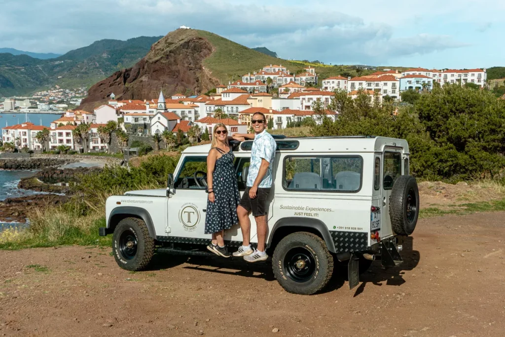 Dom and Jo standing on the side of a jeep in Madeira.