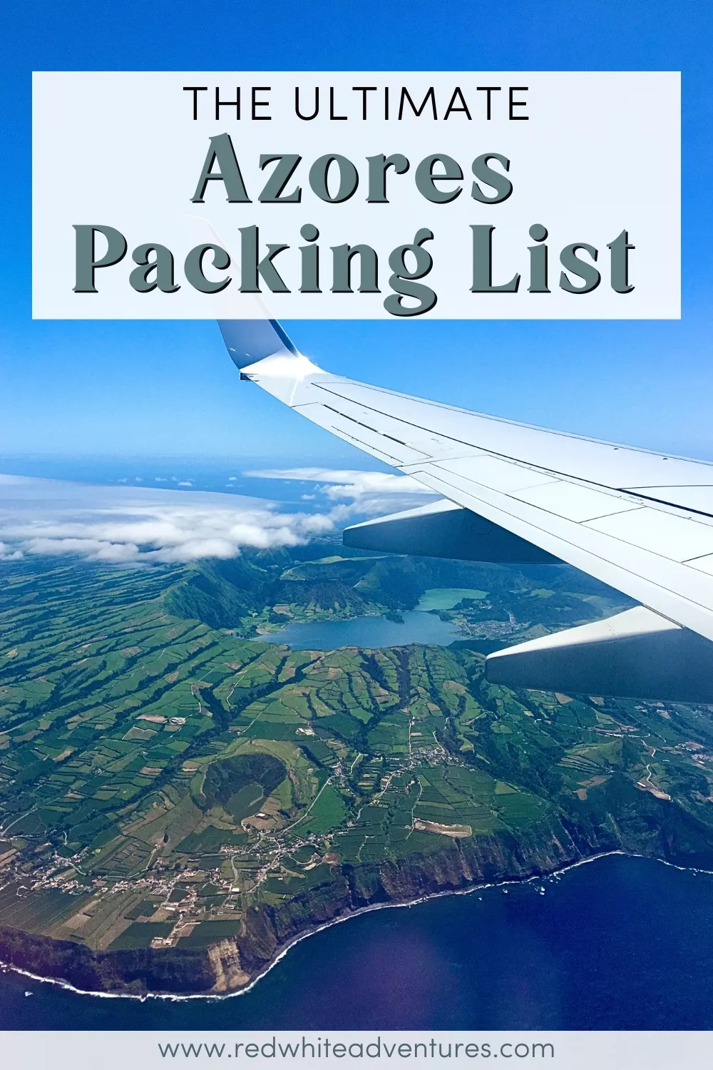 View from an airplane window showing the wing in the foreground and a vivid aerial landscape of São Miguel Island below, with green fields, crater lakes, and rugged coastline under a bright blue sky. Text overlay reads “The Ultimate Azores Packing List.”