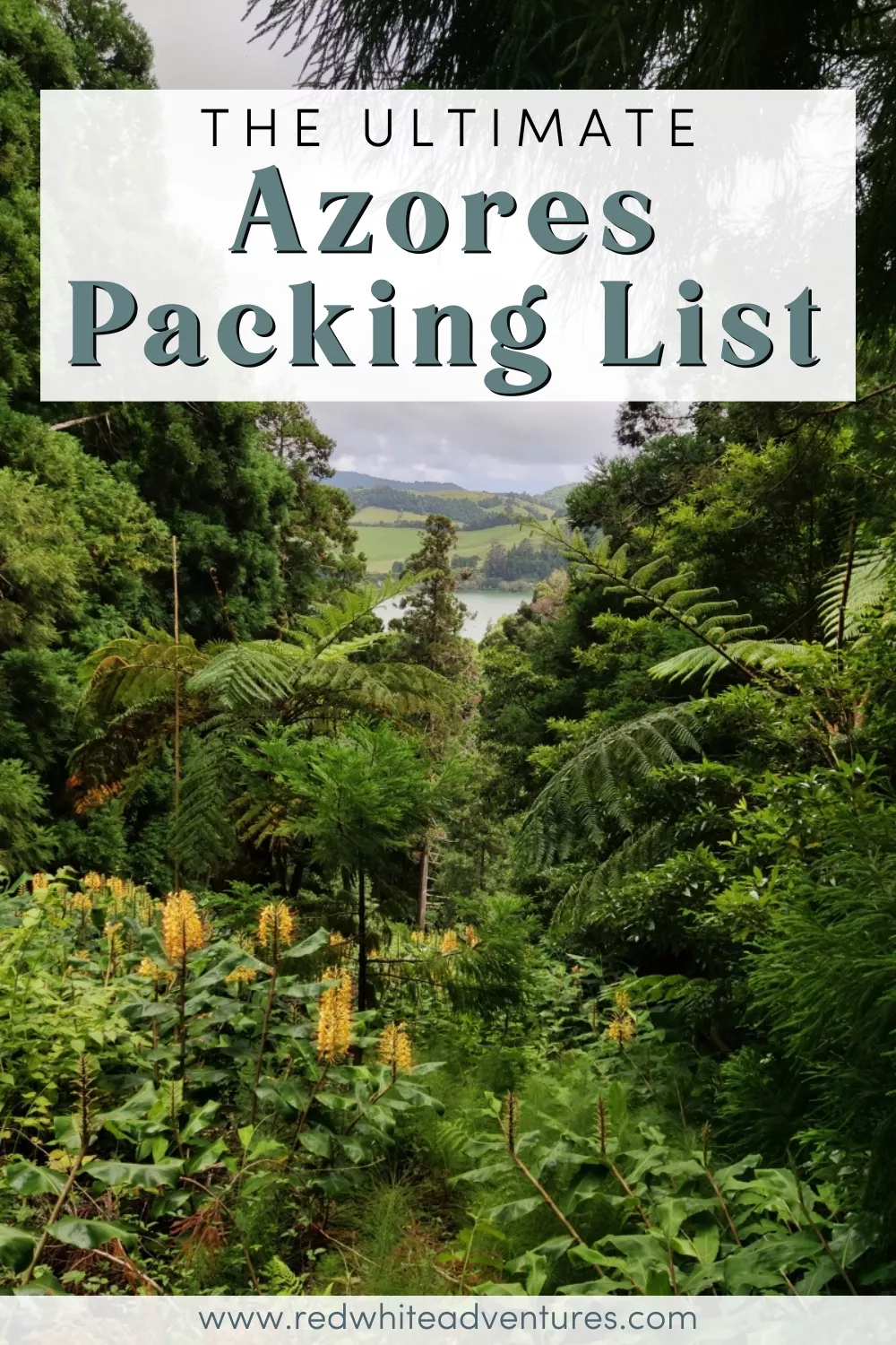 Dense tropical greenery and yellow ginger flowers frame a distant view of Lagoa das Sete Cidades on São Miguel Island. Text overlay reads “The Ultimate Azores Packing List”.