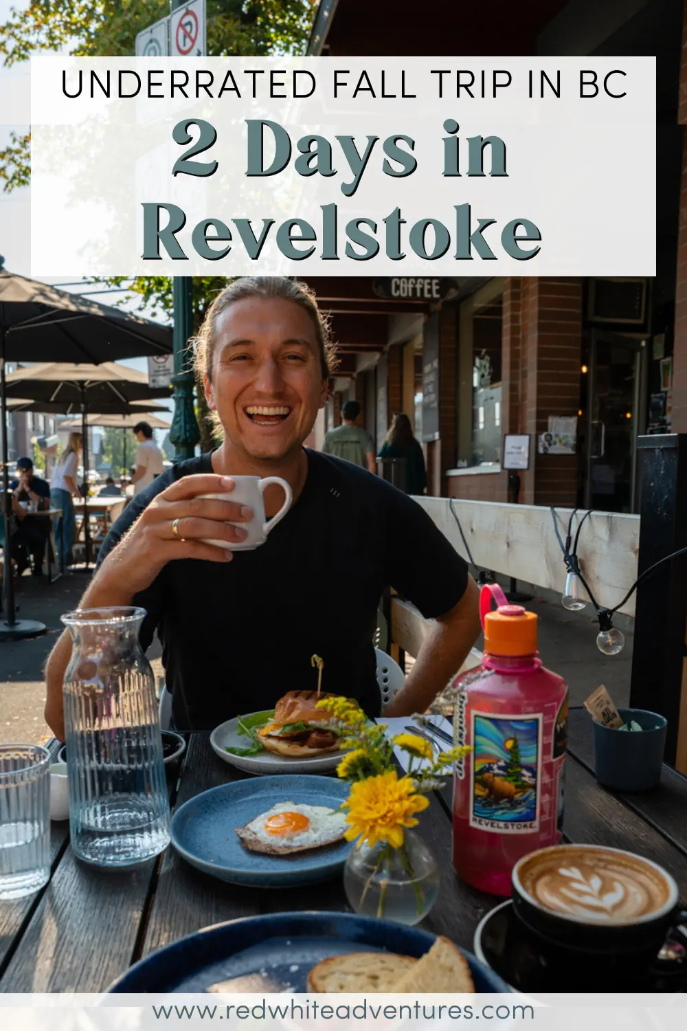 A man smiles while enjoying breakfast and a cup of coffee on the outdoor patio at Spilt Milk in downtown Revelstoke, BC. Plates of food, flowers, and drinks sit on the table, capturing the relaxed café vibe.