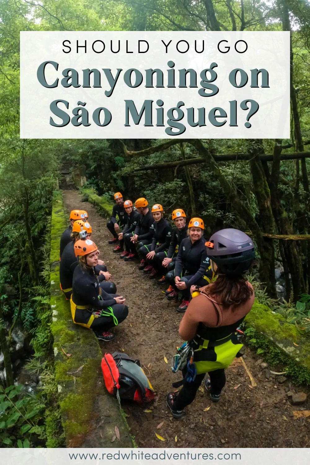 A canyoning guide speaks to a seated group wearing helmets and wetsuits along a forest trail in São Miguel. Text overlay reads, “Should you go canyoning on São Miguel?”