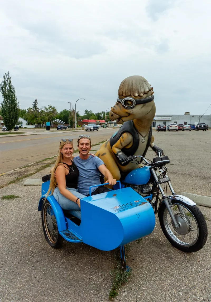 Dom and Jo taking a picture with a dinosaur in Drumheller.