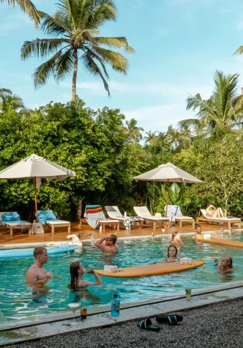 A group of people playing beer pong in the pool at Lapoint Surf Camp in Sri Lanka.