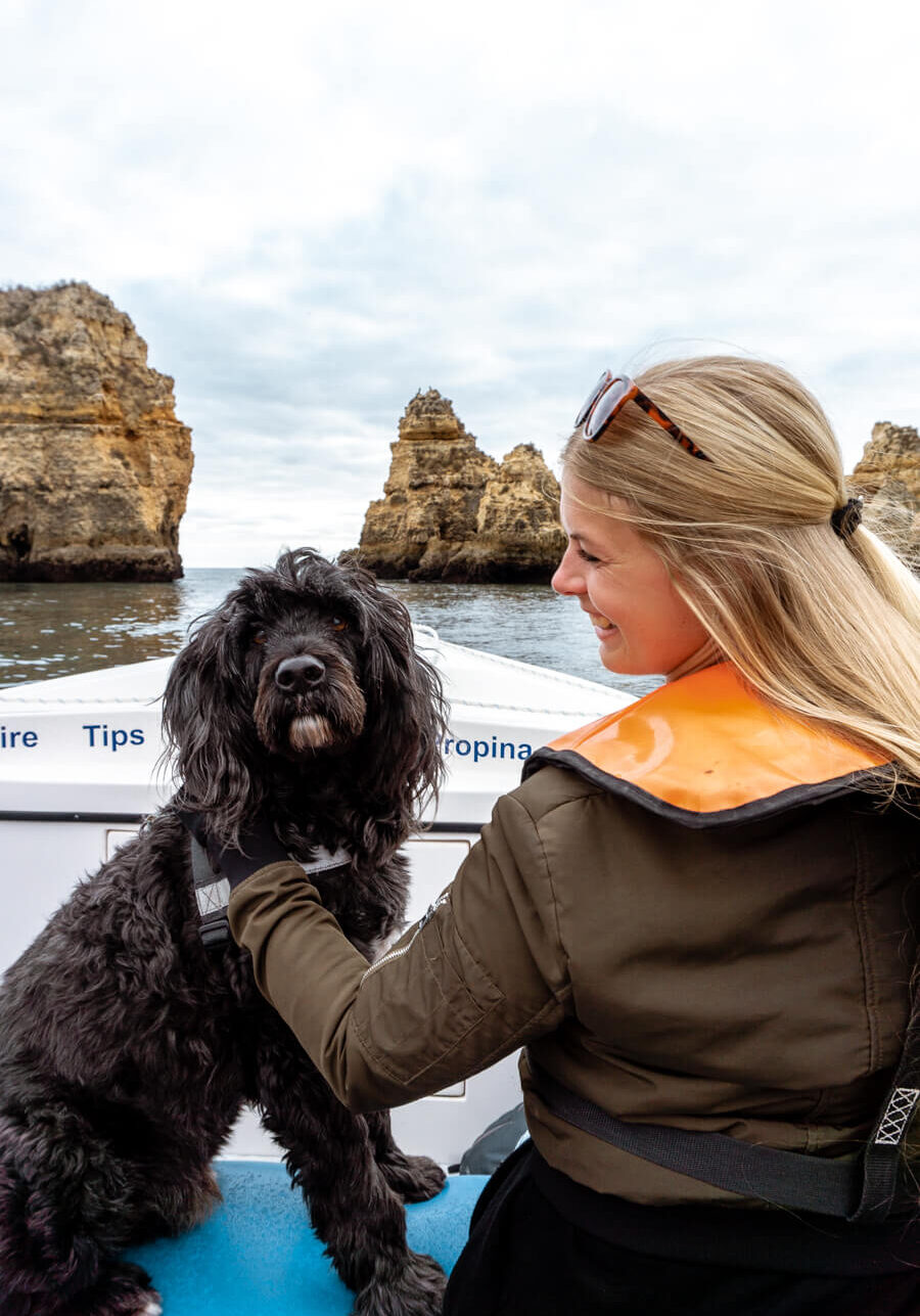 A girl with her dog on a boat tour in Lagos, Portugal.