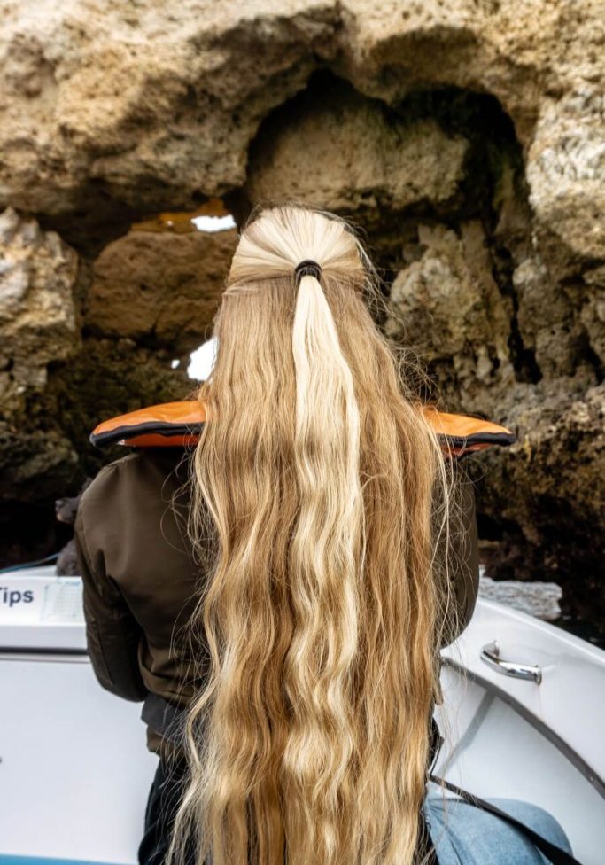 A girl with long blonde hair on a boat.