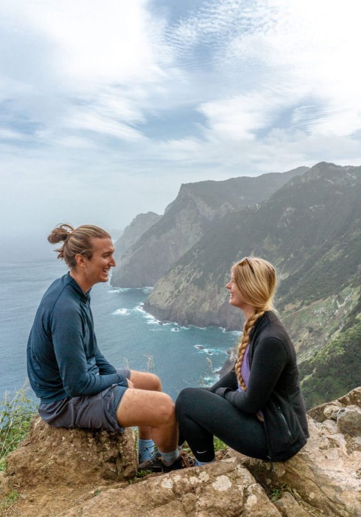A couple sitting next to a cliff in Madeira.