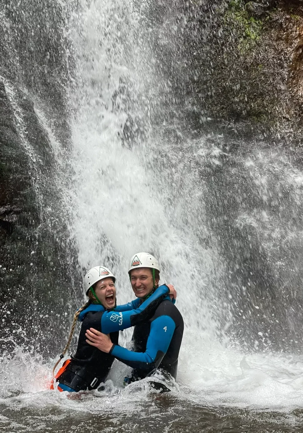 Dom and Jo laughing under a waterfall during their canyoning tour.