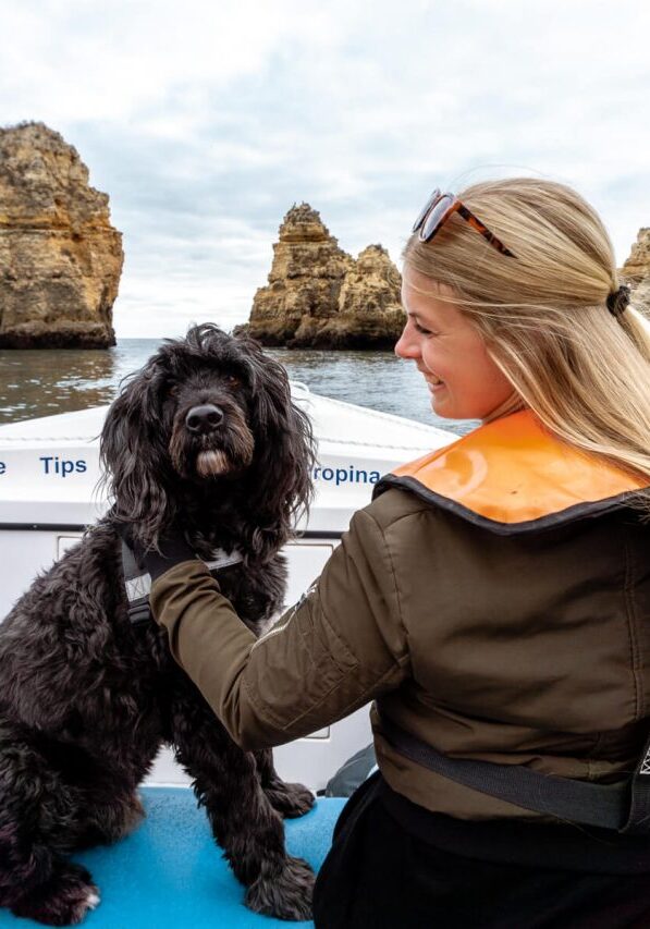 A girl with her dog on a boat tour in Lagos, Portugal.