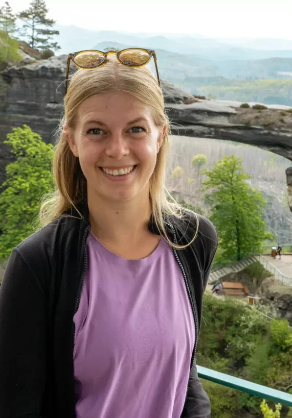 A girl standing in front of Pravčicka Brana in Bohemian Switzerland.
